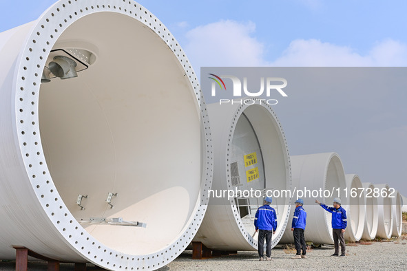 Technicians check the quality of a wind power tower barrel at a wind power equipment manufacturing enterprise in Weinan, China, on October 1...