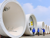 Technicians check the quality of a wind power tower barrel at a wind power equipment manufacturing enterprise in Weinan, China, on October 1...