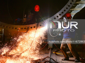 A worker works on the production line of a wind power equipment manufacturing enterprise in Baishui County, Weinan, China, on October 16, 20...