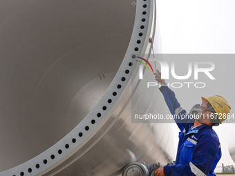 A worker works on the production line of a wind power equipment manufacturing enterprise in Baishui County, Weinan, China, on October 16, 20...