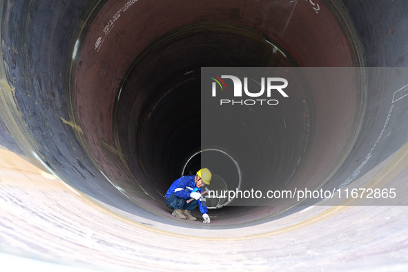 A worker works on the production line of a wind power equipment manufacturing enterprise in Baishui County, Weinan, China, on October 16, 20...