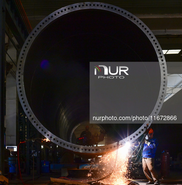 A worker works on the production line of a wind power equipment manufacturing enterprise in Baishui County, Weinan, China, on October 16, 20...