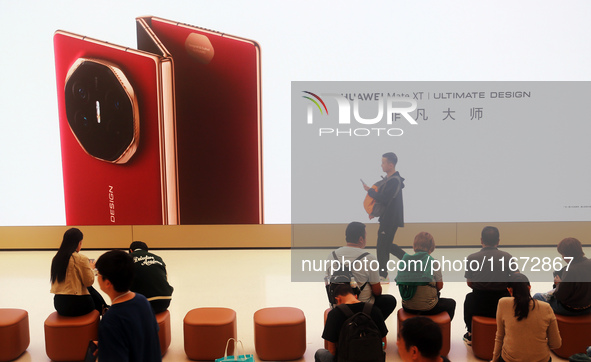 A customer experiences the Mate XT, a triple foldable screen phone, at Huawei's global flagship store in Shanghai, China, on October 15, 202...