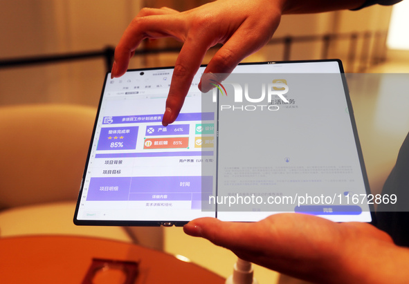 A customer experiences the Mate XT, a triple foldable screen phone, at Huawei's global flagship store in Shanghai, China, on October 15, 202...