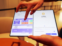 A customer experiences the Mate XT, a triple foldable screen phone, at Huawei's global flagship store in Shanghai, China, on October 15, 202...