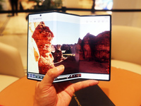 A customer experiences the Mate XT, a triple foldable screen phone, at Huawei's global flagship store in Shanghai, China, on October 15, 202...