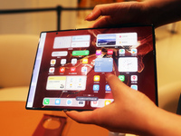 A customer experiences the Mate XT, a triple foldable screen phone, at Huawei's global flagship store in Shanghai, China, on October 15, 202...