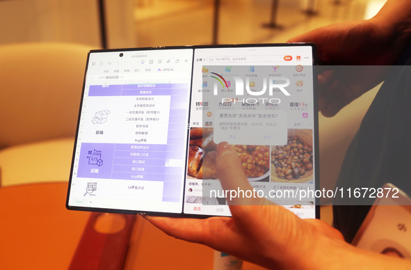 A customer experiences the Mate XT, a triple foldable screen phone, at Huawei's global flagship store in Shanghai, China, on October 15, 202...