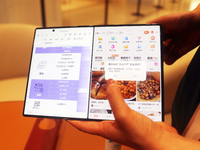 A customer experiences the Mate XT, a triple foldable screen phone, at Huawei's global flagship store in Shanghai, China, on October 15, 202...