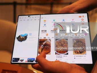 A customer experiences the Mate XT, a triple foldable screen phone, at Huawei's global flagship store in Shanghai, China, on October 15, 202...