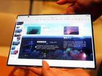 A customer experiences the Mate XT, a triple foldable screen phone, at Huawei's global flagship store in Shanghai, China, on October 15, 202...