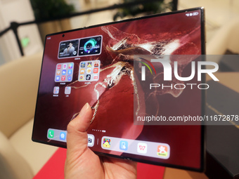 A customer experiences the Mate XT, a triple foldable screen phone, at Huawei's global flagship store in Shanghai, China, on October 15, 202...