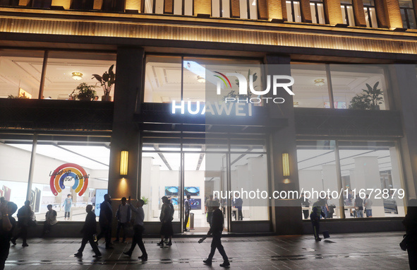 Pedestrians walk past Huawei's global flagship store in Shanghai, China, on October 15, 2024. 