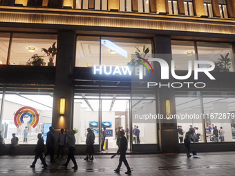 Pedestrians walk past Huawei's global flagship store in Shanghai, China, on October 15, 2024. (