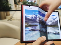 A customer experiences the Mate XT, a triple foldable screen phone, at Huawei's global flagship store in Shanghai, China, on October 15, 202...