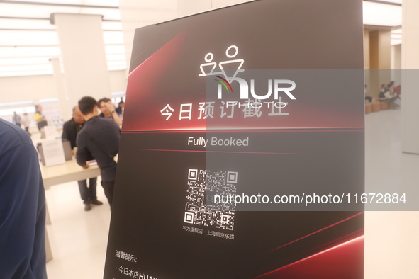 A customer experiences the Mate XT, a triple foldable screen phone, at Huawei's global flagship store in Shanghai, China, on October 15, 202...