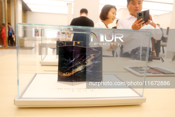 A customer experiences the Mate XT, a triple foldable screen phone, at Huawei's global flagship store in Shanghai, China, on October 15, 202...