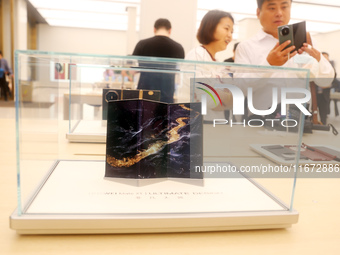 A customer experiences the Mate XT, a triple foldable screen phone, at Huawei's global flagship store in Shanghai, China, on October 15, 202...