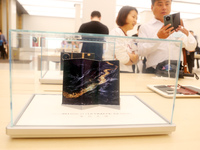 A customer experiences the Mate XT, a triple foldable screen phone, at Huawei's global flagship store in Shanghai, China, on October 15, 202...