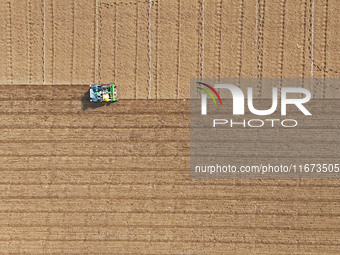 A farmer drives a seeder to sow winter wheat in a test field at the Yantai Academy of Agricultural Sciences in Yantai, China, on October 17,...