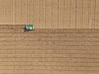 A farmer drives a seeder to sow winter wheat in a test field at the Yantai Academy of Agricultural Sciences in Yantai, China, on October 17,...