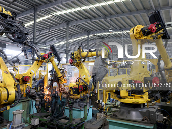 A robot makes auto parts at the production workshop of Zhenhua Zhende Auto Parts Co., Ltd. in Ningde, China, on October 17, 2024. (