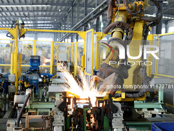 A robot makes auto parts at the production workshop of Zhenhua Zhende Auto Parts Co., Ltd. in Ningde, China, on October 17, 2024. (