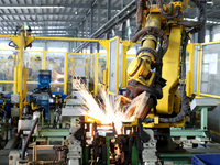 A robot makes auto parts at the production workshop of Zhenhua Zhende Auto Parts Co., Ltd. in Ningde, China, on October 17, 2024. (