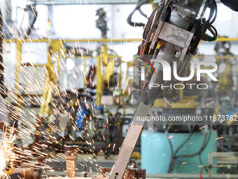 A robot makes auto parts at the production workshop of Zhenhua Zhende Auto Parts Co., Ltd. in Ningde, China, on October 17, 2024. (