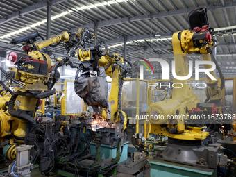 A robot makes auto parts at the production workshop of Zhenhua Zhende Auto Parts Co., Ltd. in Ningde, China, on October 17, 2024. (