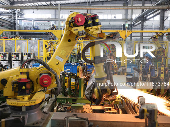 A robot makes auto parts at the production workshop of Zhenhua Zhende Auto Parts Co., Ltd. in Ningde, China, on October 17, 2024. (