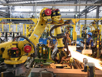 A robot makes auto parts at the production workshop of Zhenhua Zhende Auto Parts Co., Ltd. in Ningde, China, on October 17, 2024. (