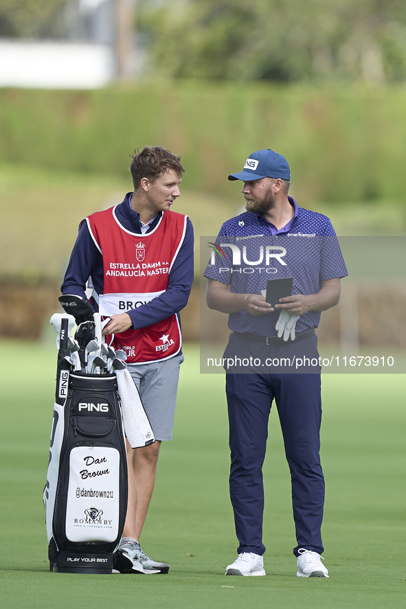 Daniel Brown of England talks with his caddie on the 14th hole on day one of the Estrella Damm N.A. Andalucia Masters 2024 at Real Club de G...