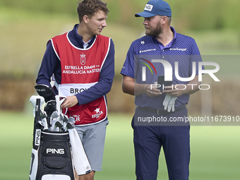 Daniel Brown of England talks with his caddie on the 14th hole on day one of the Estrella Damm N.A. Andalucia Masters 2024 at Real Club de G...