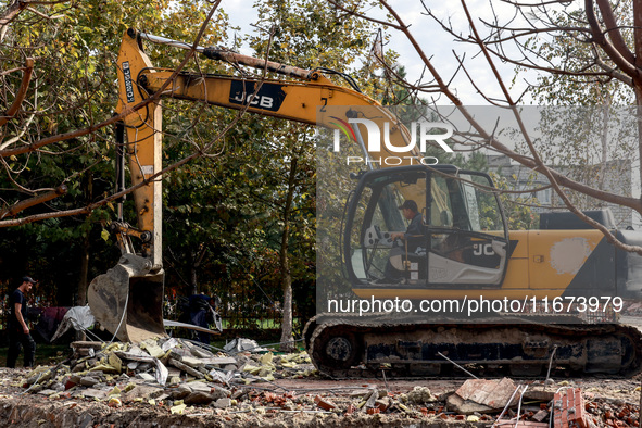 An excavator removes the rubble near the Delta hotel and restaurant damaged by a Russian drone attack in Vylkove, Ukraine, on October 11, 20...