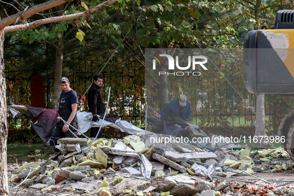 Workers clear away the rubble near the Delta hotel and restaurant damaged by a Russian drone attack in Vylkove, Ukraine, on October 11, 2024...