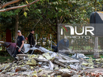 Workers clear away the rubble near the Delta hotel and restaurant damaged by a Russian drone attack in Vylkove, Ukraine, on October 11, 2024...