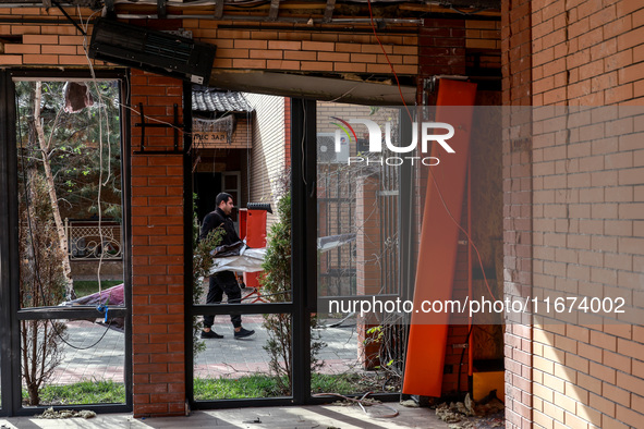 A man carries a piece of rubble near the Delta hotel and restaurant damaged by a Russian drone attack in Vylkove, Odesa region, southern Ukr...