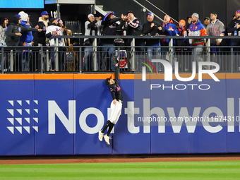 Two fans catch Los Angeles Dodgers Enrique Hernandez #8 home run as New York Mets outfielder Brandon Nimmo #9 leaps in vain during the sixth...