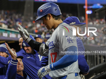 Los Angeles Dodgers' Shohei Ohtani #17 is congratulated by teammates after hitting a home run in the eighth inning in Game 3 of the baseball...