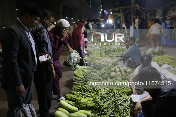 Residents buy vegetables beside a road in Dhaka, Bangladesh, on October 17, 2024. Vegetable prices rise after Bangladesh faces several flood...