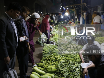 Residents buy vegetables beside a road in Dhaka, Bangladesh, on October 17, 2024. Vegetable prices rise after Bangladesh faces several flood...