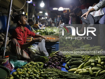 Residents buy vegetables beside a road in Dhaka, Bangladesh, on October 17, 2024. Vegetable prices rise after Bangladesh faces several flood...