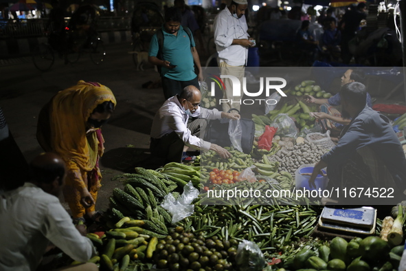 Residents buy vegetables beside a road in Dhaka, Bangladesh, on October 17, 2024. Vegetable prices rise after Bangladesh faces several flood...