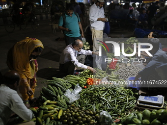 Residents buy vegetables beside a road in Dhaka, Bangladesh, on October 17, 2024. Vegetable prices rise after Bangladesh faces several flood...