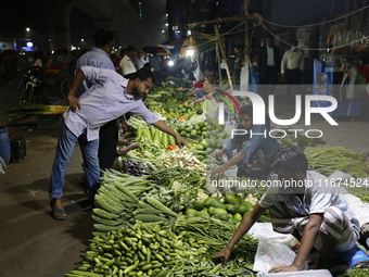 Residents buy vegetables beside a road in Dhaka, Bangladesh, on October 17, 2024. Vegetable prices rise after Bangladesh faces several flood...