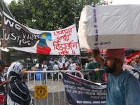 Indian daily laborers carry goods and walk past a doctor protest site in Kolkata, India, on October 17, 2024. (