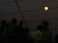 People watch Hunter's Supermoon in Colombo, Sri Lanka, on October 17, 2024. October's full moon is known as the Hunter's Moon because it is...