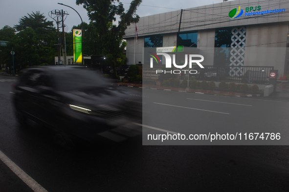 Motorized vehicles pass by Indonesia's Social Security Agency office on the main road of Medan City in North Sumatra, Indonesia, on October...