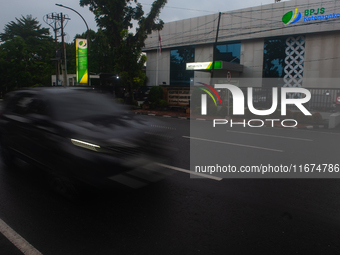 Motorized vehicles pass by Indonesia's Social Security Agency office on the main road of Medan City in North Sumatra, Indonesia, on October...